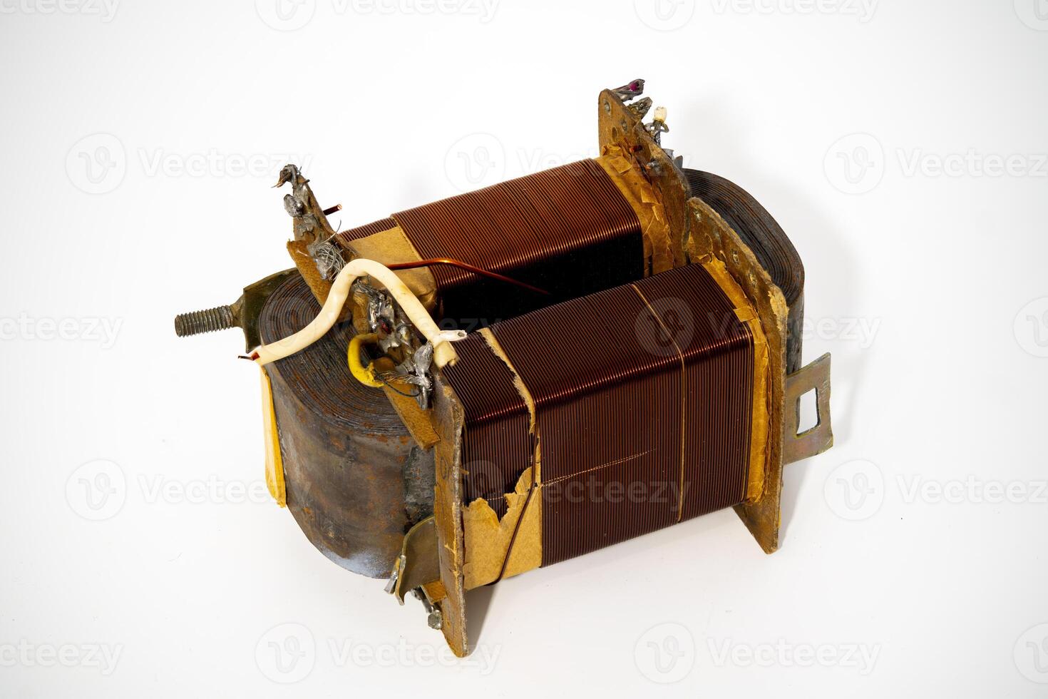Old electrical transformer with copper windings and rusty casing photo