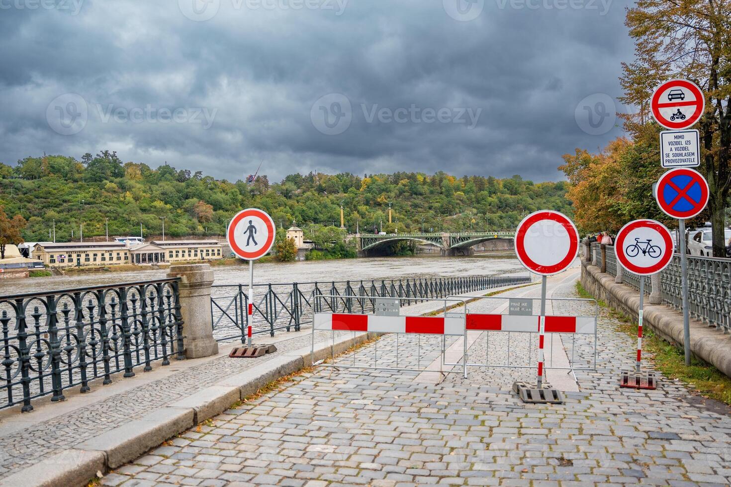 Road signs indicating that entry to the embankment is prohibited. Flood in Prague. View of Bridge over the flooding river Vltava, Prague. High quality photo