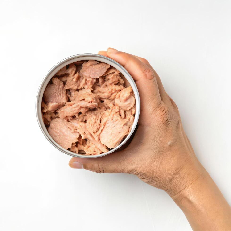 Top View of Hands holding a Canned Tuna in Oil on a White Background photo