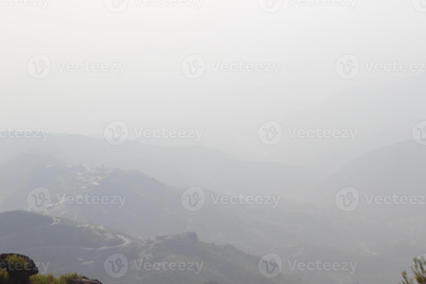 A person standing on a hill overlooking a valley photo
