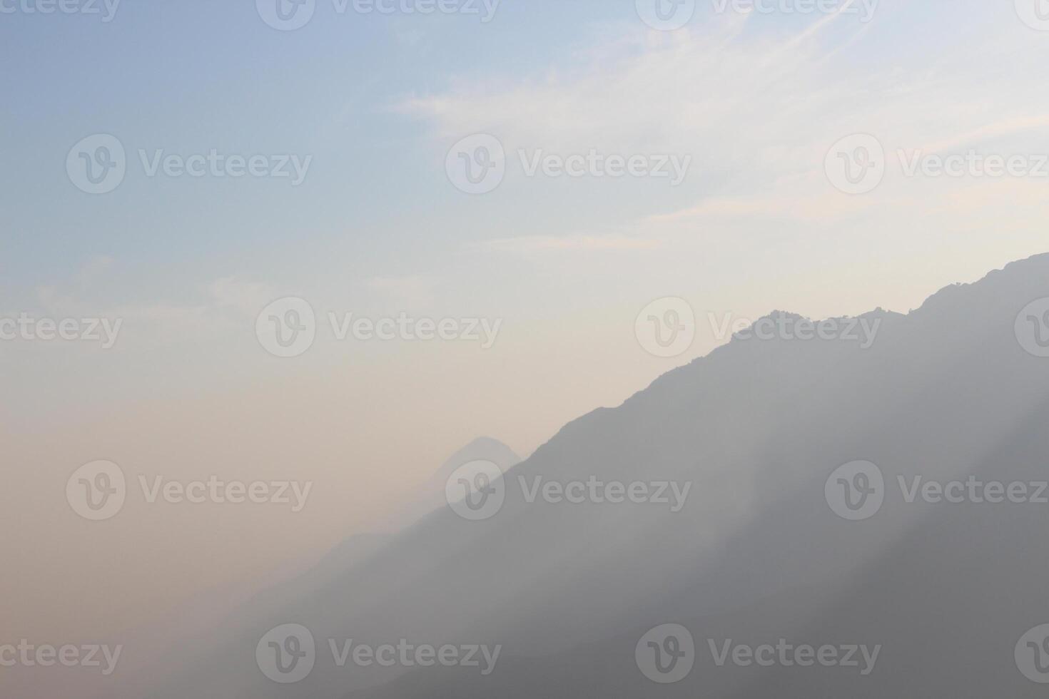 A plane flying over a mountain range with a clear sky photo