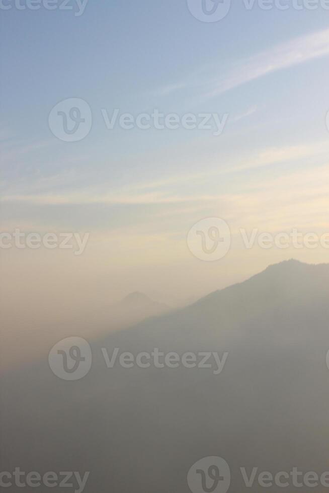 A plane flying over a mountain range with a view of the ocean photo