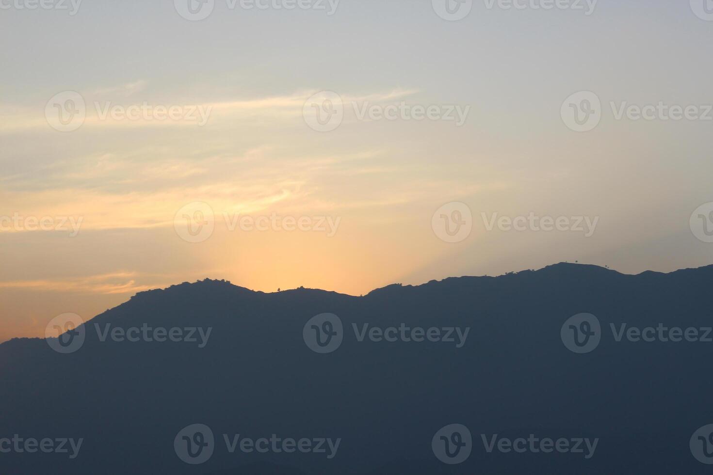 A plane flying over a mountain range at sunset photo
