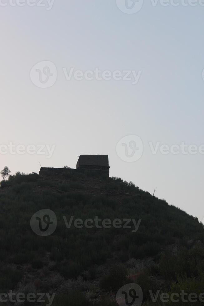 A building on top of a hill with a blue sky photo