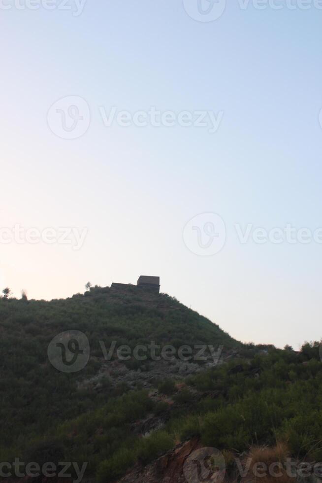A hill with a small building on top of it photo