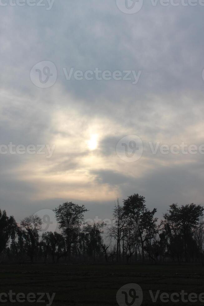 A cloudy sky with a sun shining through it photo