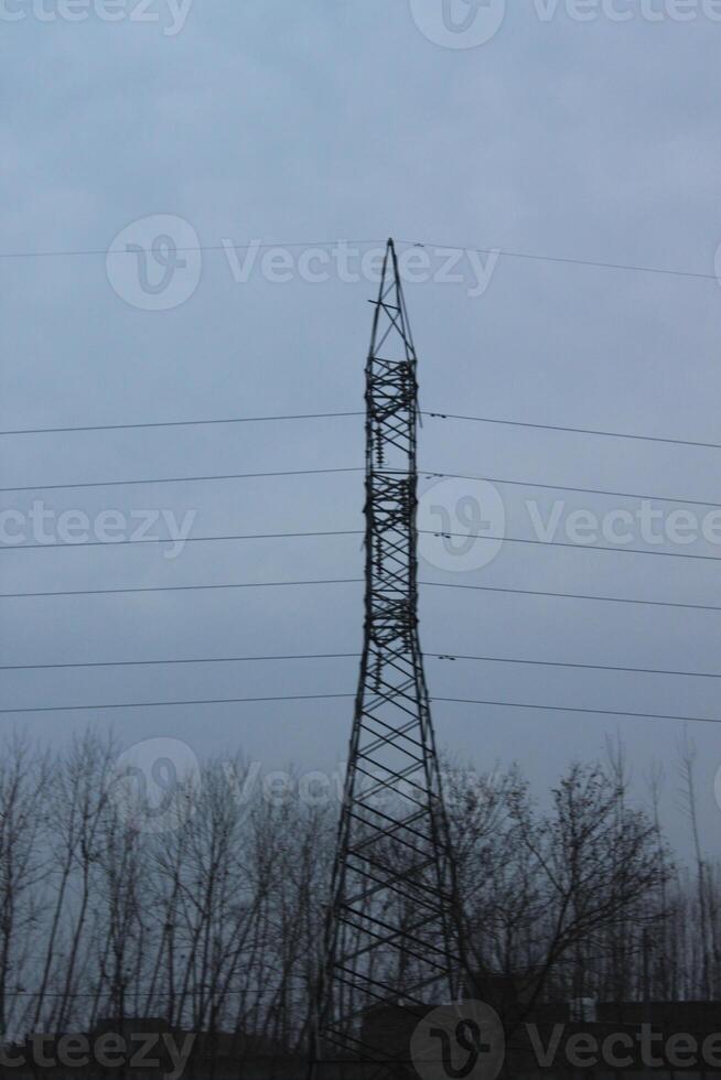 A tall power line with trees in the background photo