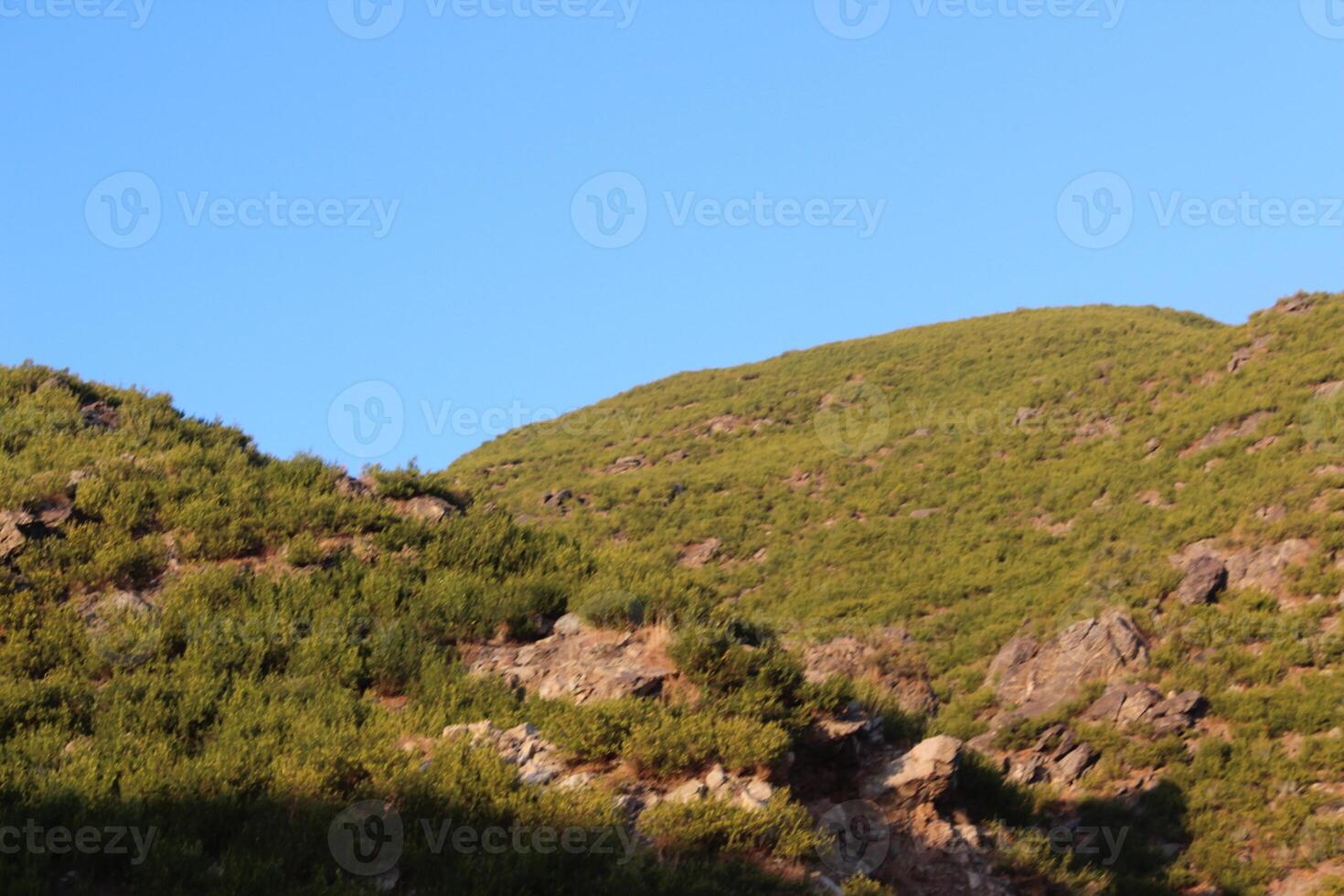 A mountain with a small hill in the background photo