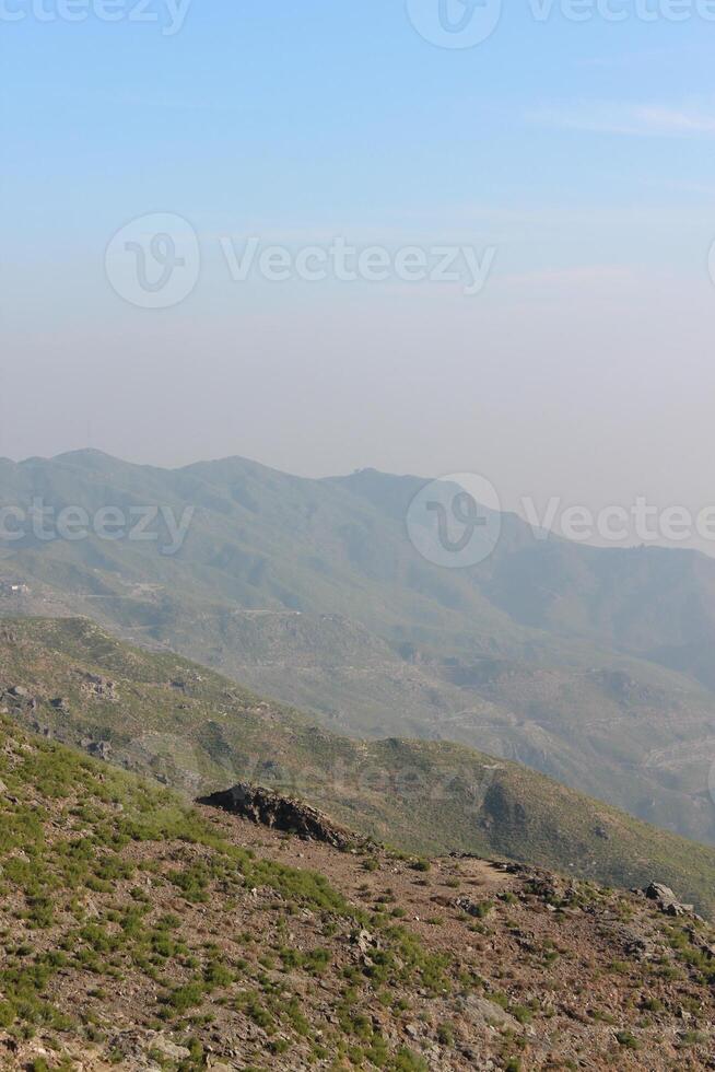 A person standing on a hill with a kite photo