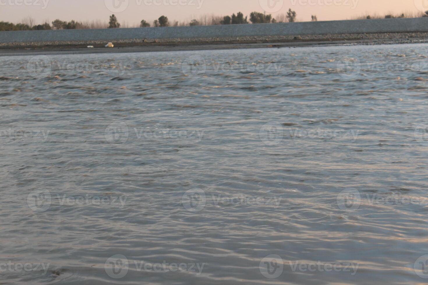 A man is standing in the water with a surfboard photo