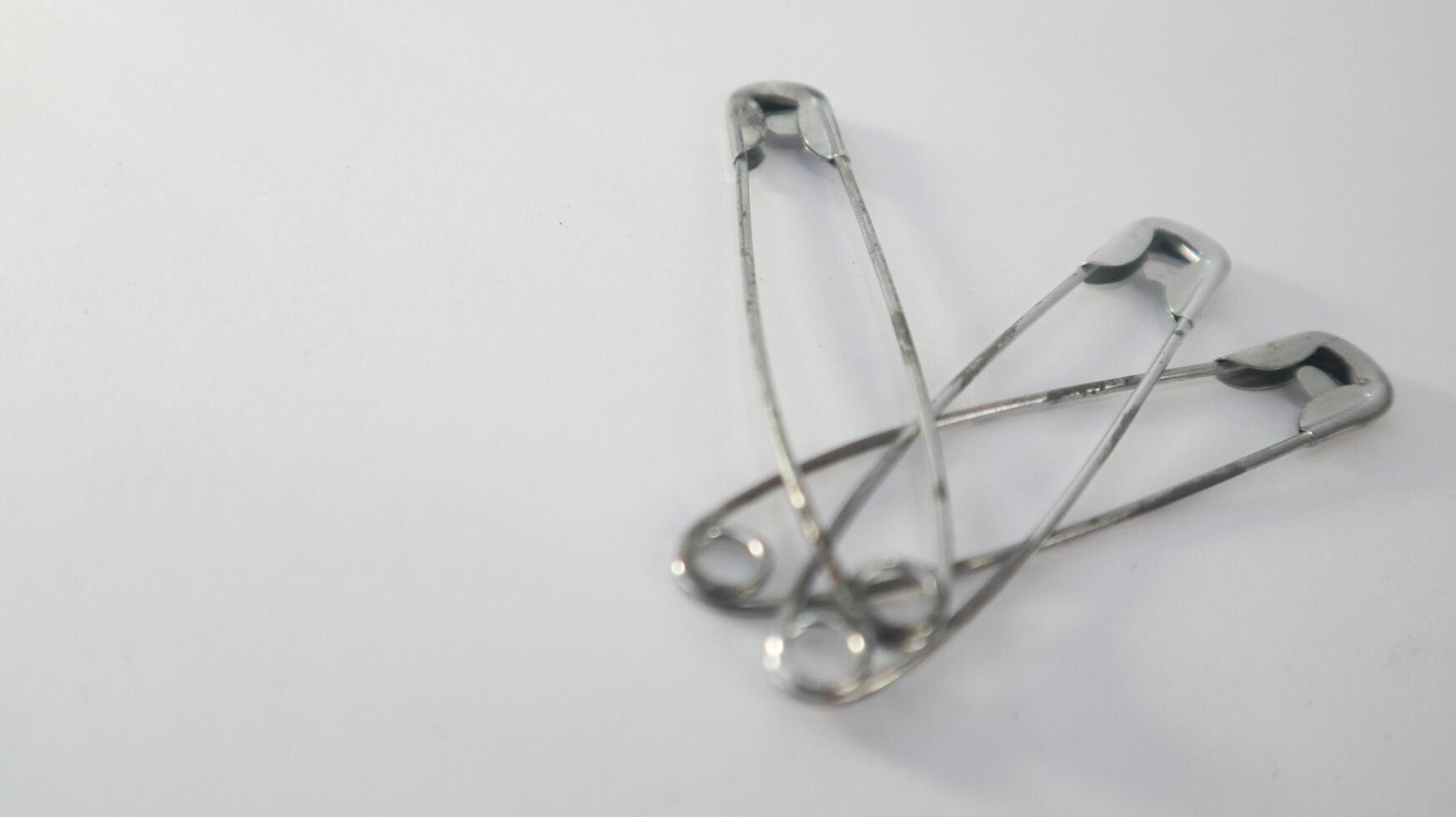 a photo of several safety pins on a white background