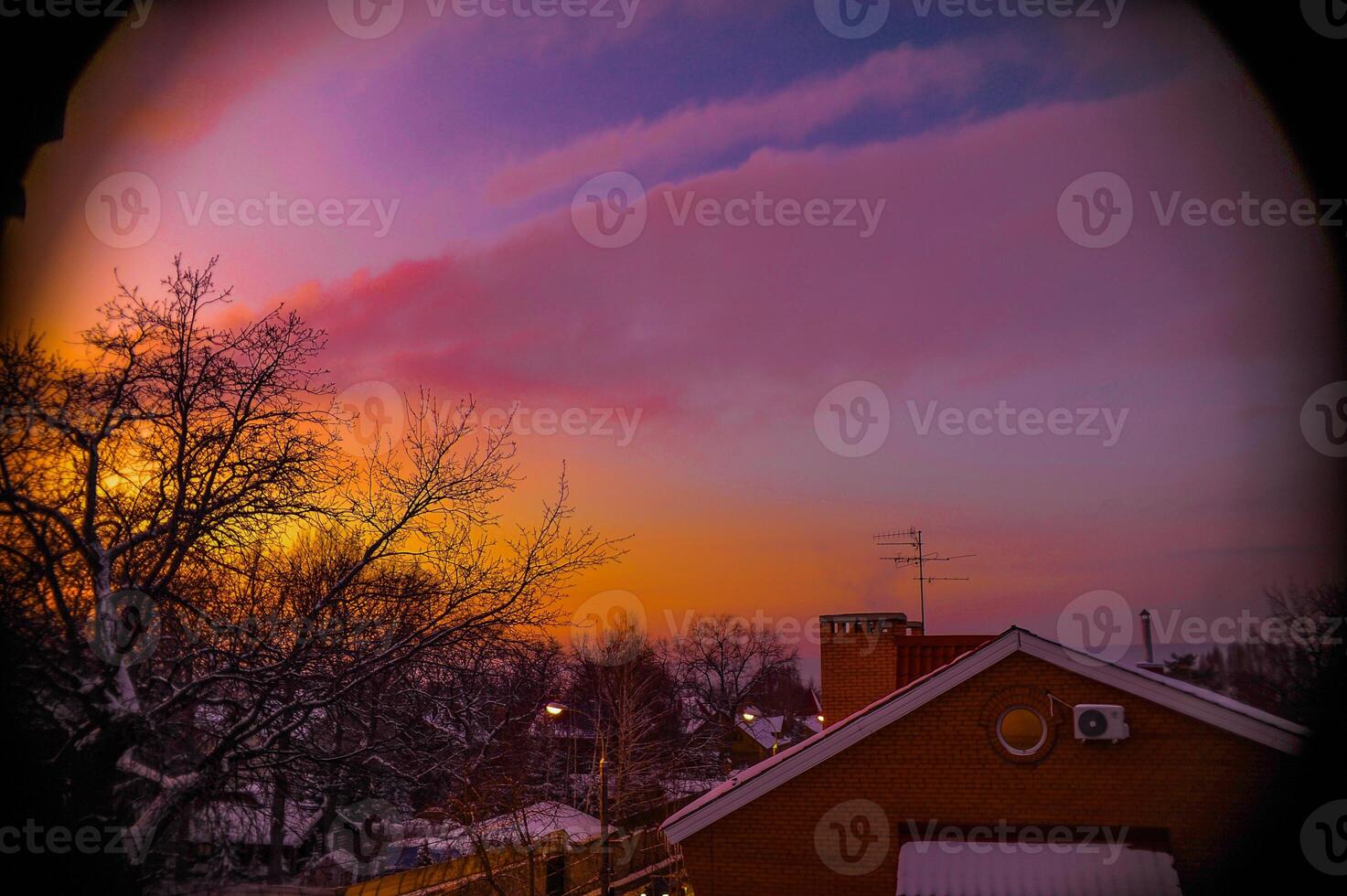 Sunset with a house in front and trees in the back photo