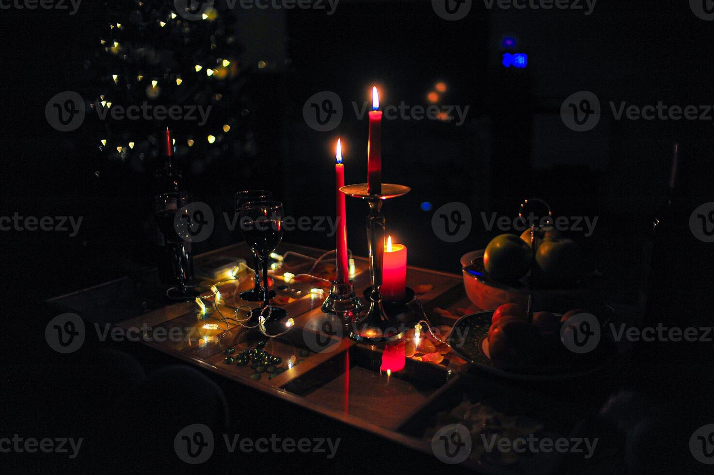 A table with candles and a lovely Christmas tree in the background photo