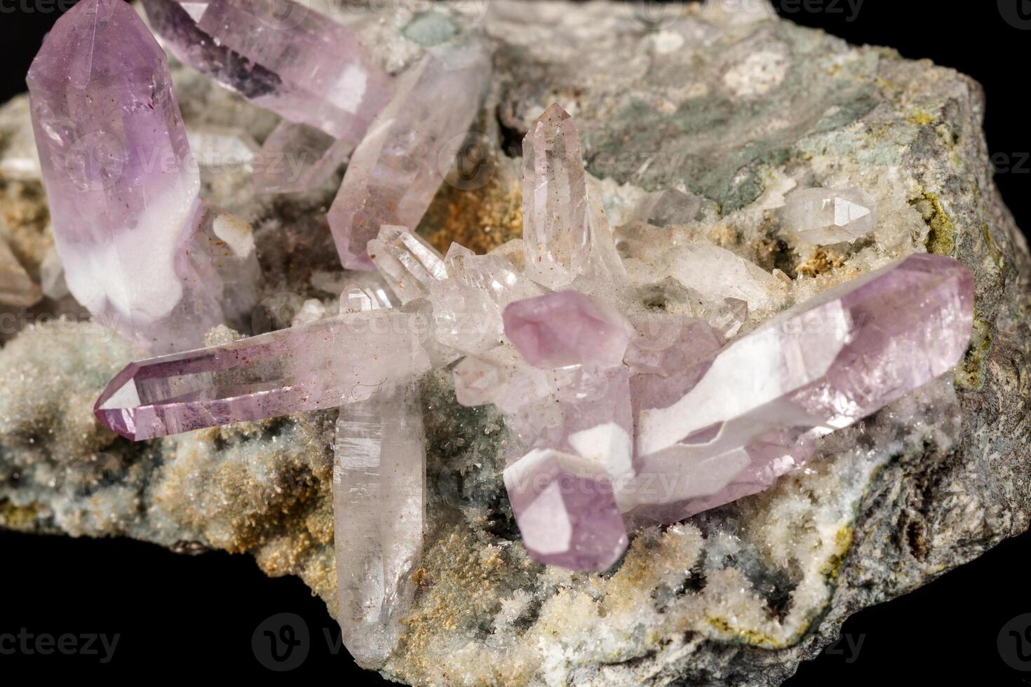 Macro mineral stone Amethyst crystals in rock on a black background close up photo