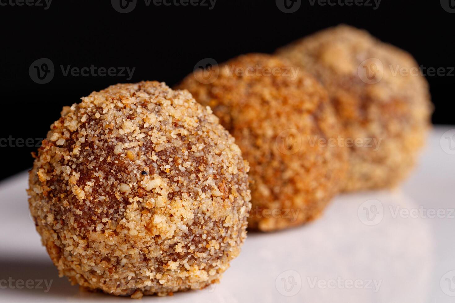 Beautiful candy truffle on a white plate on a black background close up photo