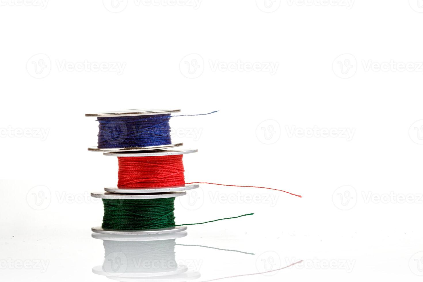 spools of thread in blue, red, green colors on photo