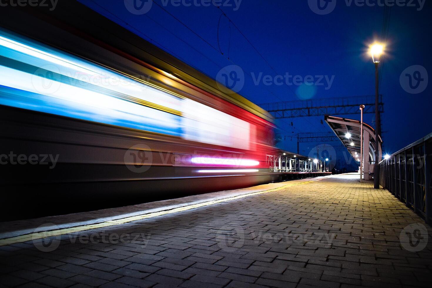 Evening arrival of the train on an empty platform. Phto taken with a shutter speed. Rays of light. Blur. Evening railway station. photo
