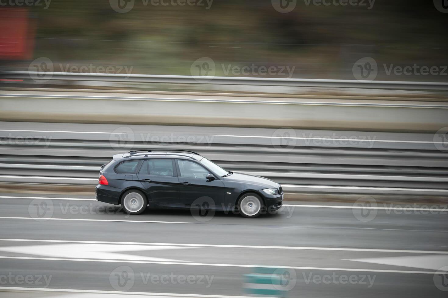 black, passenger car on the highway in motion with a blurred background photo