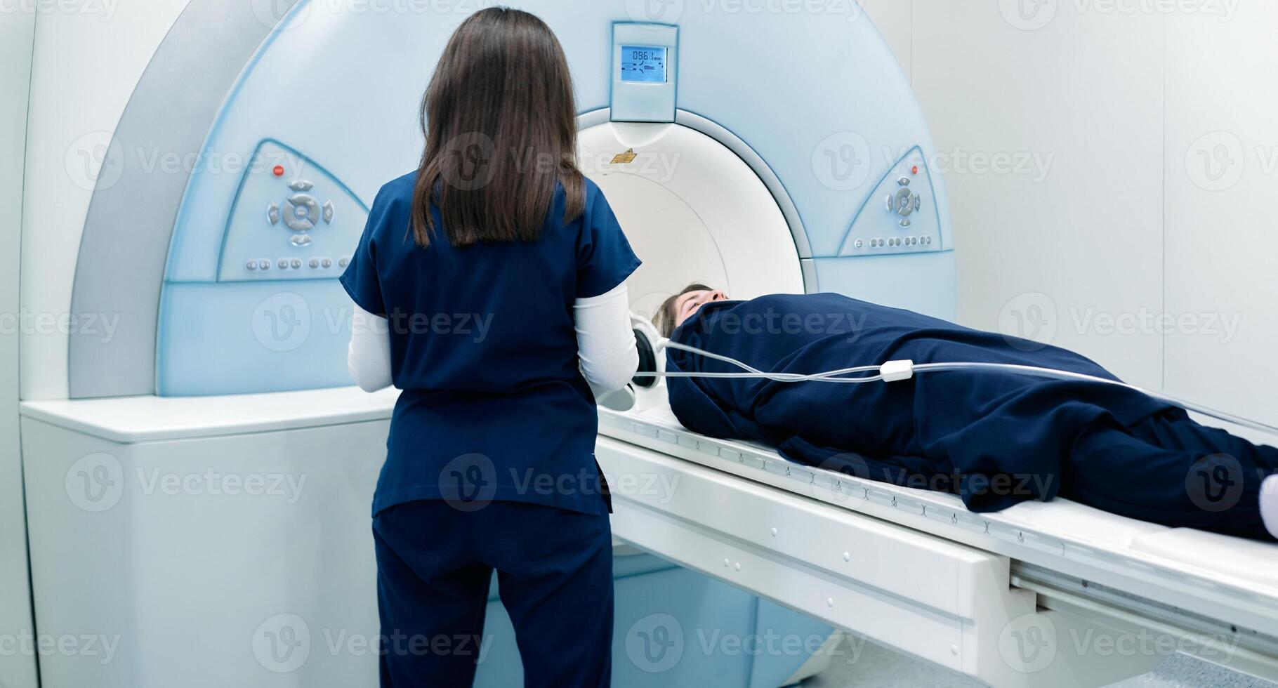 A nurse or medical technician prepares a patient for an MRI scan or MRI scanner photo