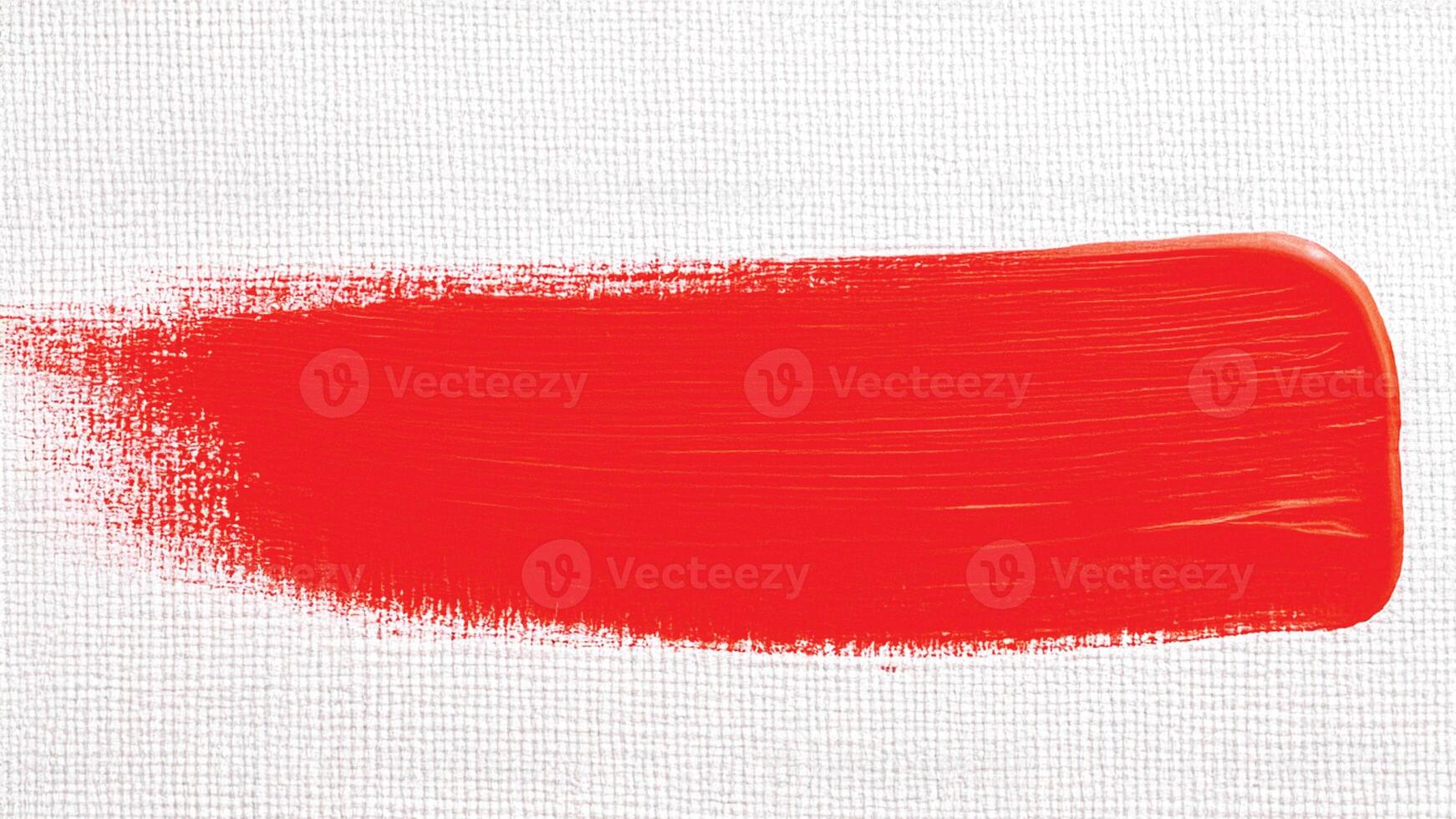Bright scarlet paint stroke with rough finish and visible brush lines. photo