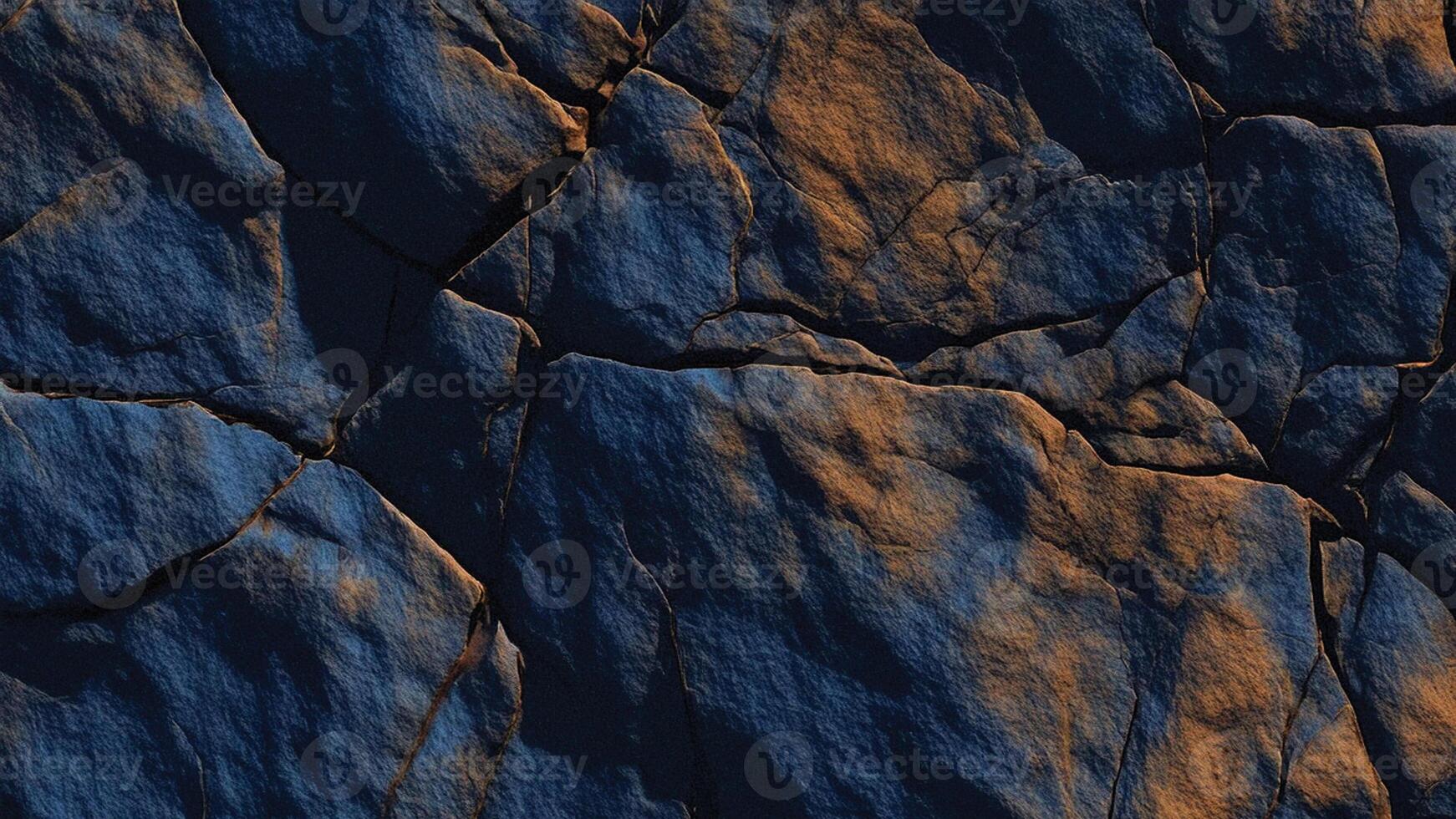 Textured dark blue slate rock with deep fissures and rust streaks, showcasing rugged geological formations perfect for architectural designs, abstract stone backgrounds, and nature-inspired surfaces photo