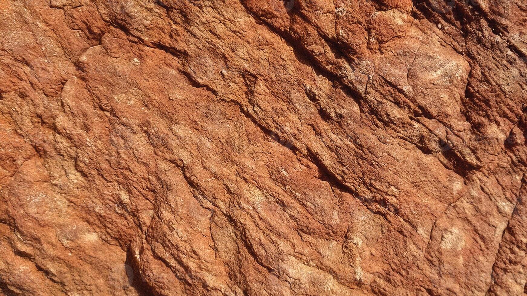 Light brown sedimentary rock with deep cracks and textured layers, showcasing natural erosion perfect for architectural design and background patterns. photo
