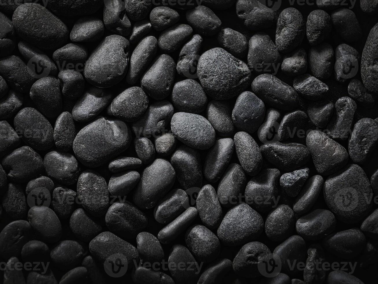 Smooth black stones create an intriguing abstract natural texture in soft light photo