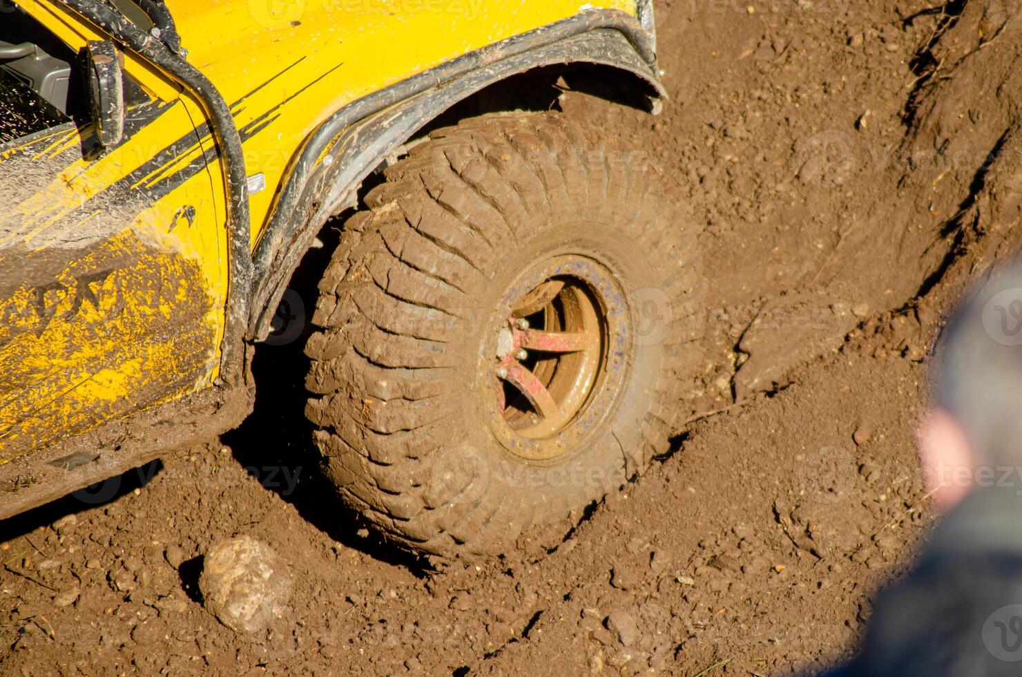 partial view of the wheel of a four-wheel drive car on a muddy road an off road concept background photo