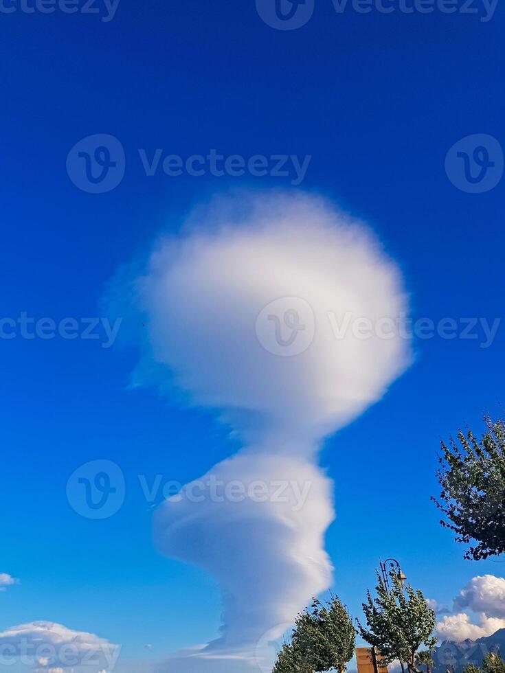 Nature cloud formation set against the backdrop of a pristine blue sky. The beauty of the pure sky highlights the dramatic contours of the cloud, reminiscent of an approaching storm. photo