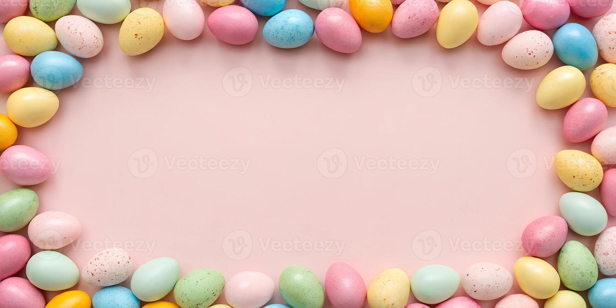 Flat lay composition of pastel-colored Easter eggs forming a frame on a pink background. Holiday mockup with copy space photo