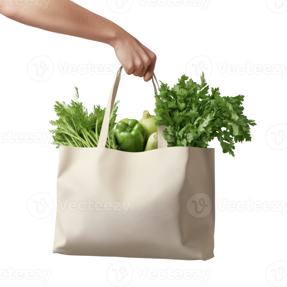 Hand holding a beige tote bag filled with green vegetables png