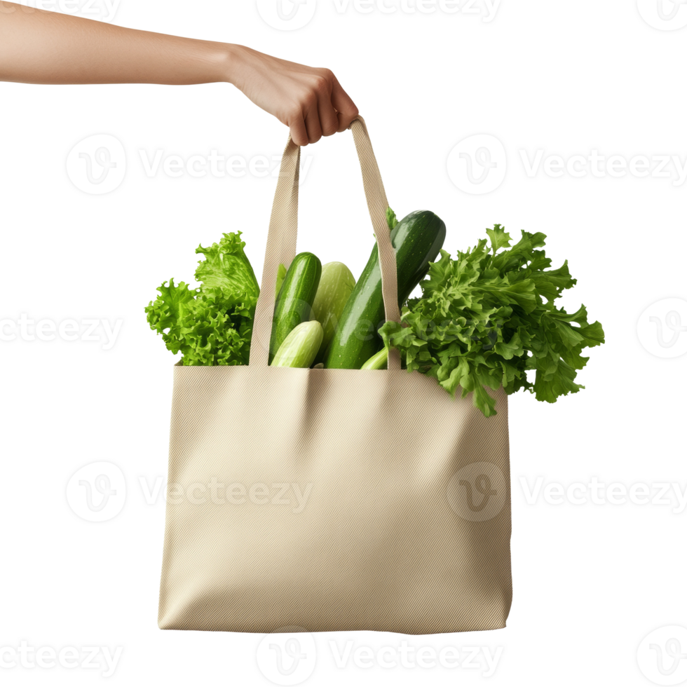 A hand holds a beige tote bag filled with green vegetables png