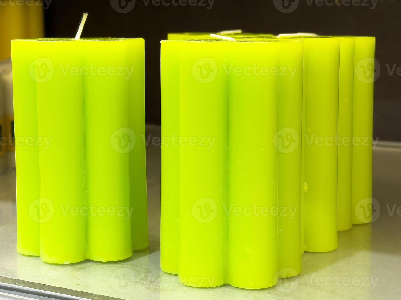 Bright green pillar candles displayed on shelf with scalloped edges photo