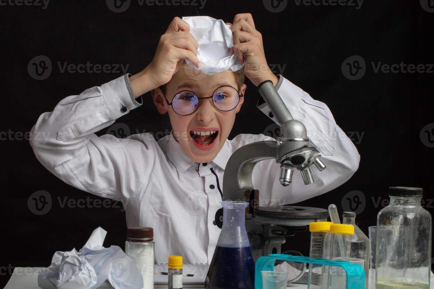 The boy is a scientific researcher with a microscope doing experiments in the laboratory. photo