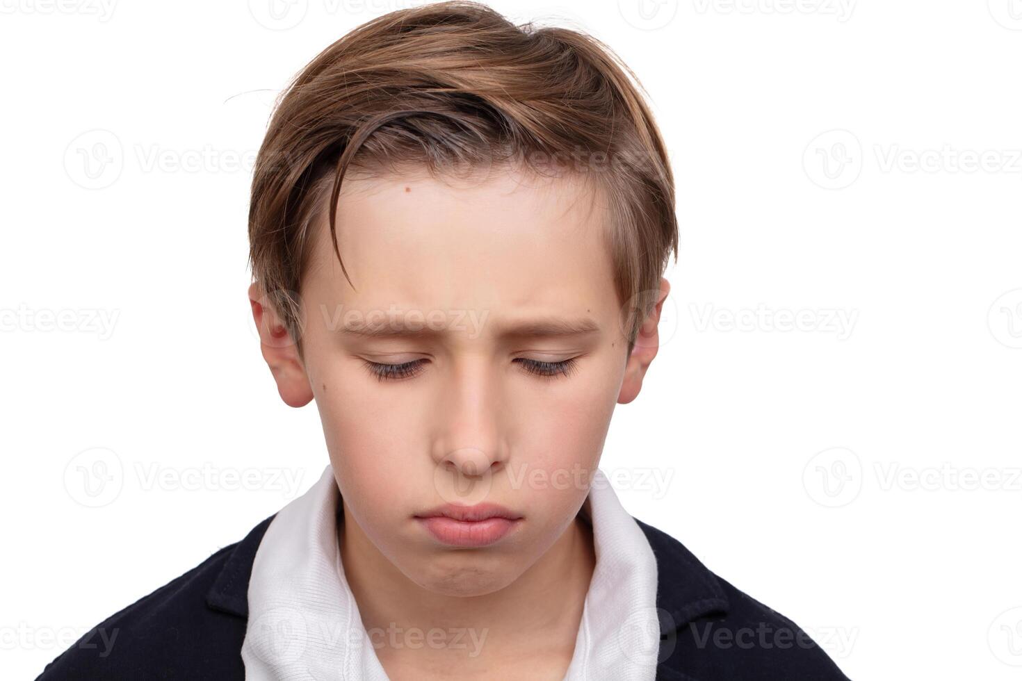 Portrait of a sad little boy with his eyes closed on a white background close-up.The emotion of guilt. photo