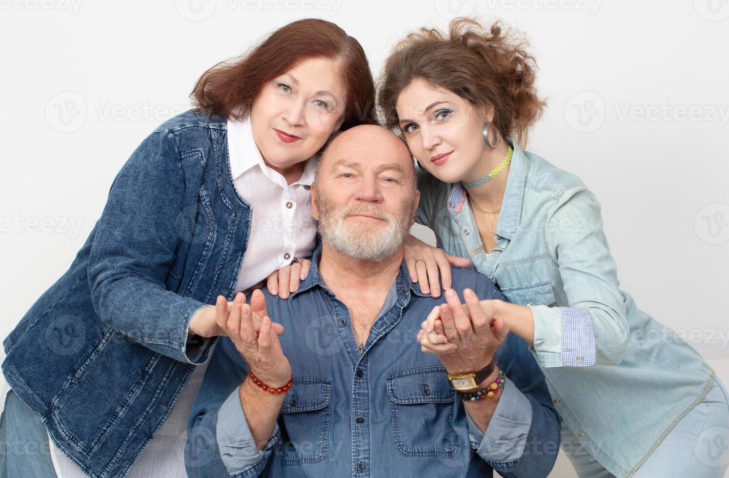 Family portrait of an adult daughter and elderly parents on a gray background. T photo