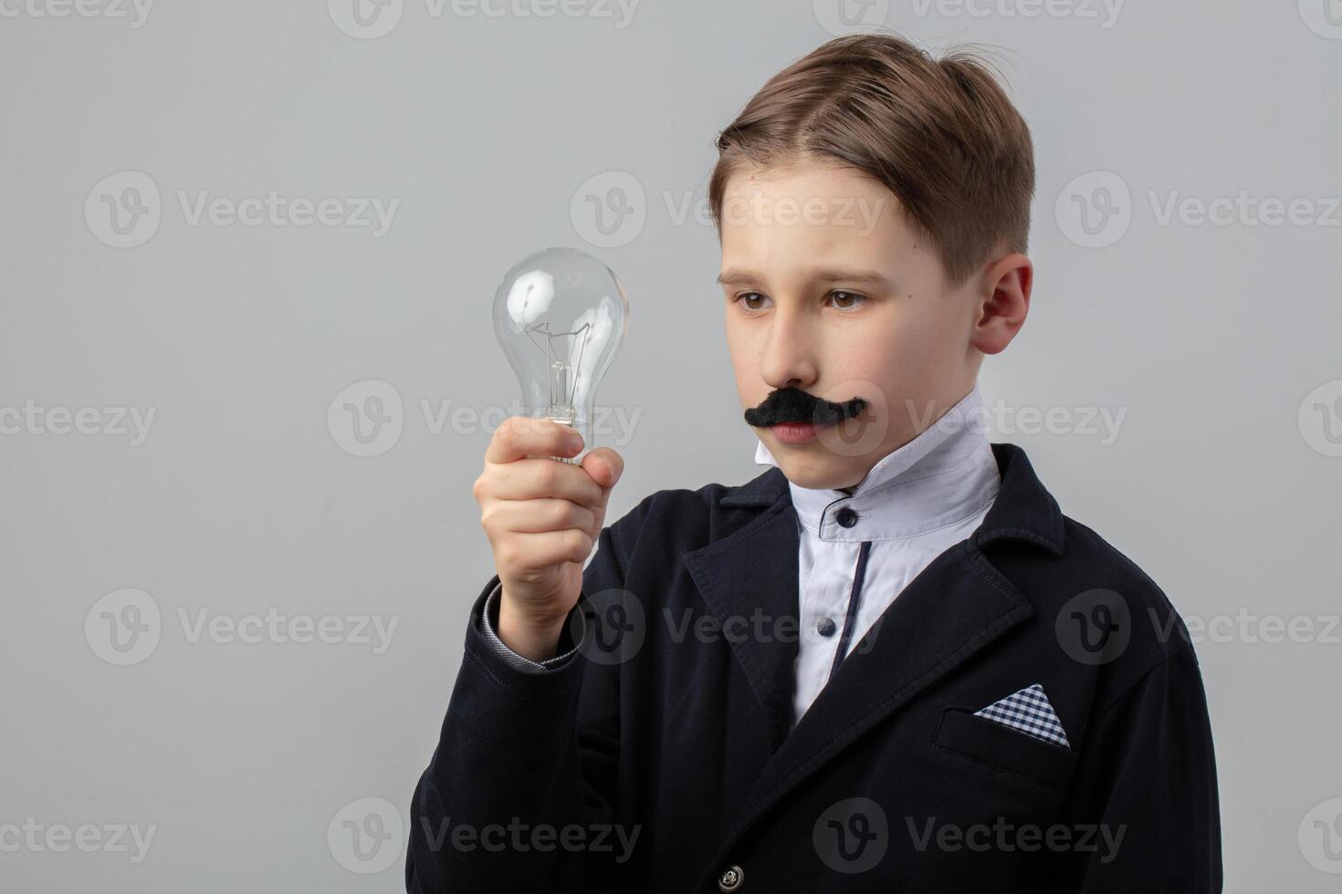 Portrait of a funny scientist boy with an electric light bulb in his hands. photo