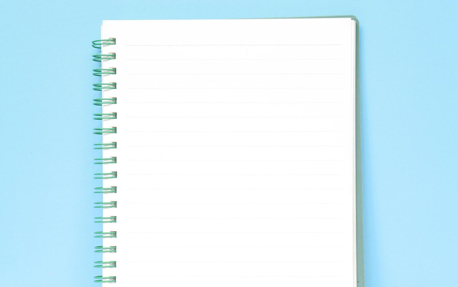 Top view of blank note paper isolated on blue background with copy space. Back to school and education concept, a journaling book photo