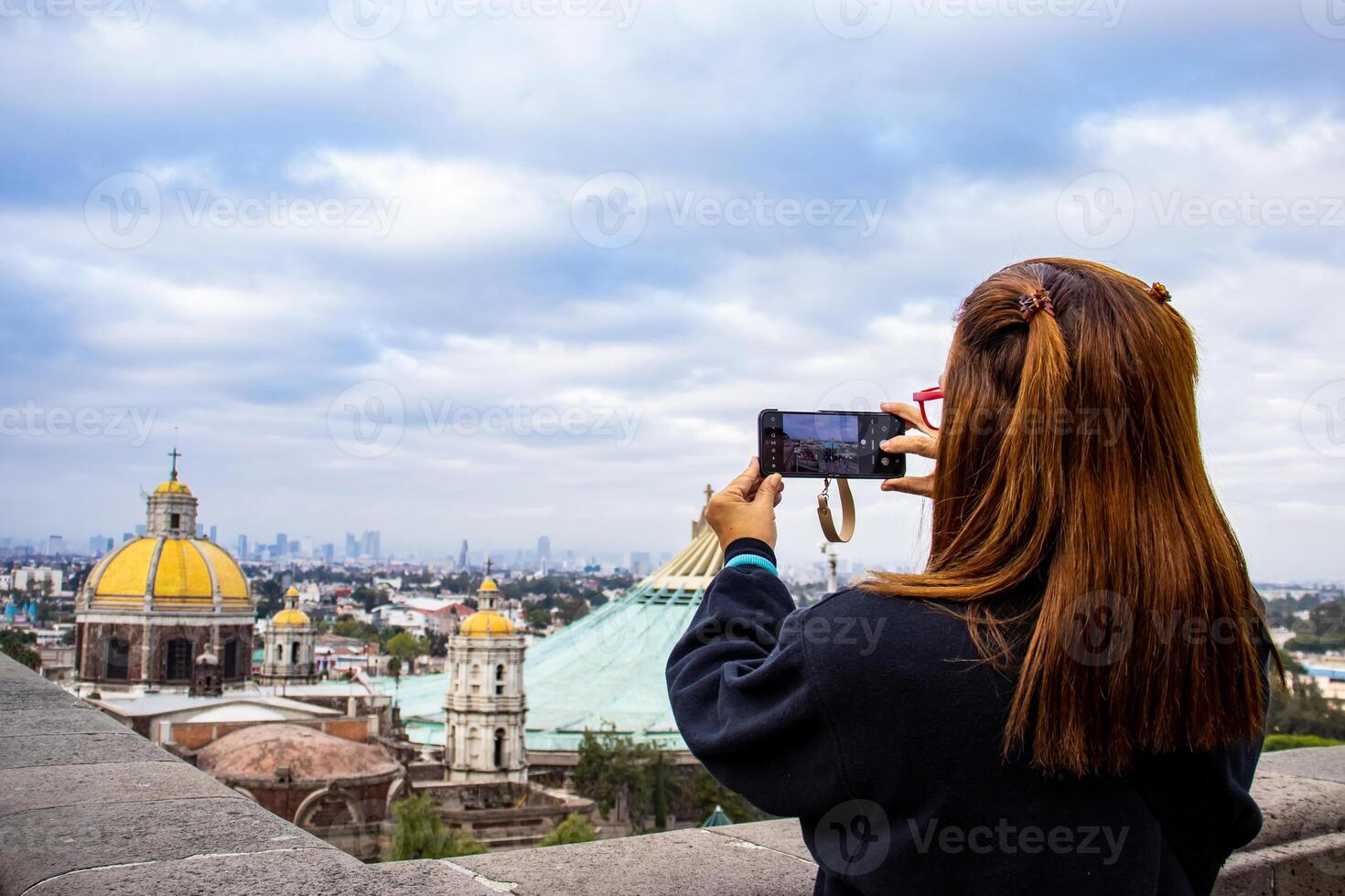 Female tourist at the Basilica of Guadalupe and taking pictures from the Tepeyac Hill in Mexico City. photo