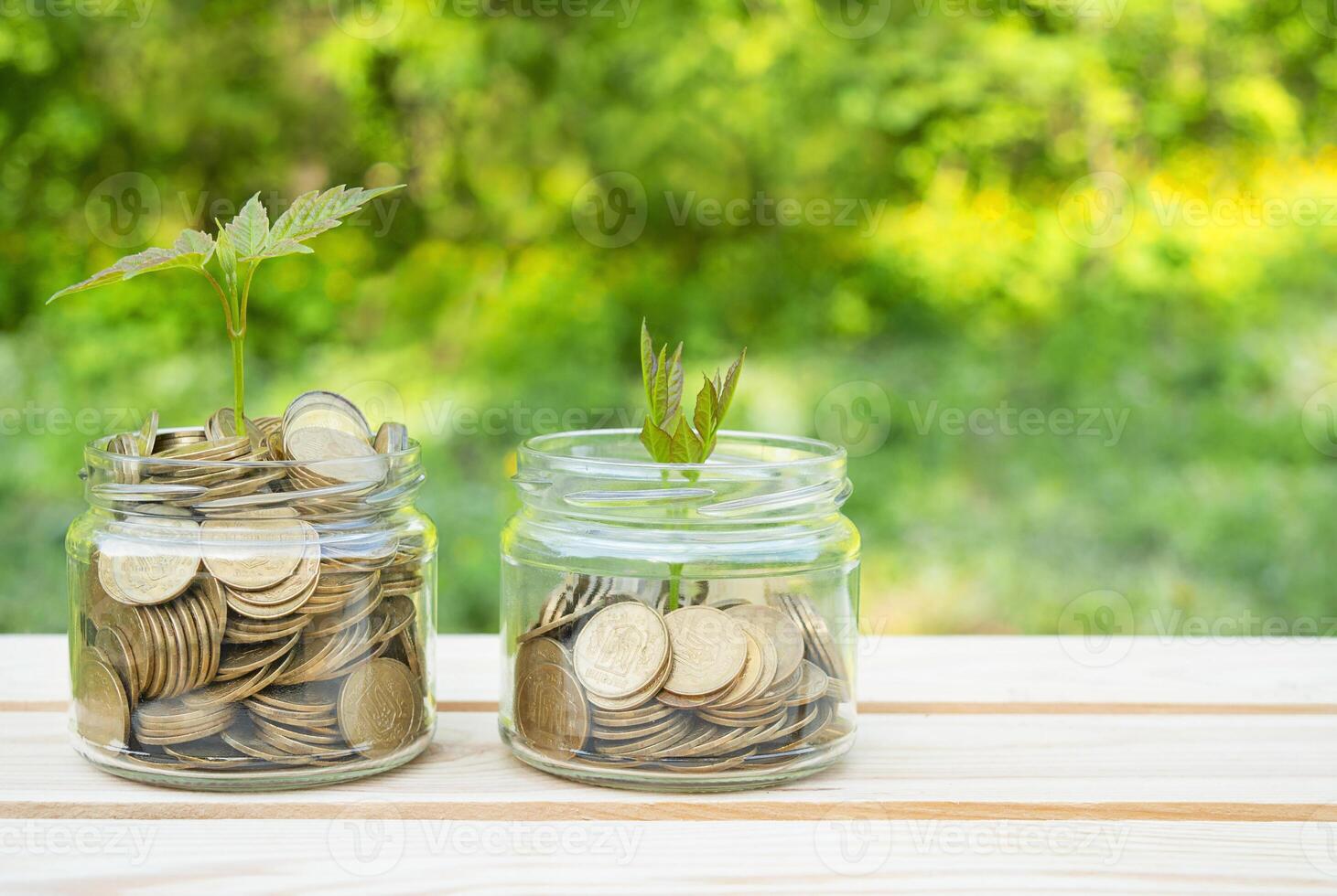 Business concept. Glass jars filled with coins stand on a wooden table. Family budget, accumulation of money. Copy space. photo