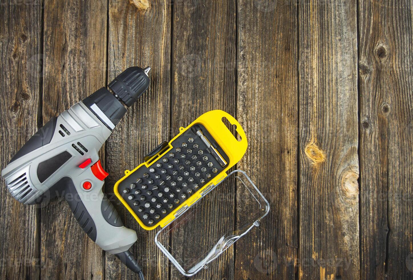 Electric drill with nozzles for working on a wooden table. Copy space. photo
