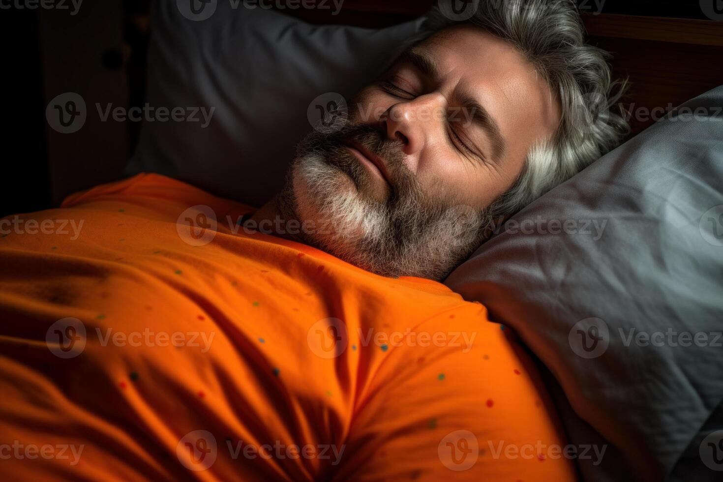 Grey haired bearded man sleeping peacefully in bed at night photo