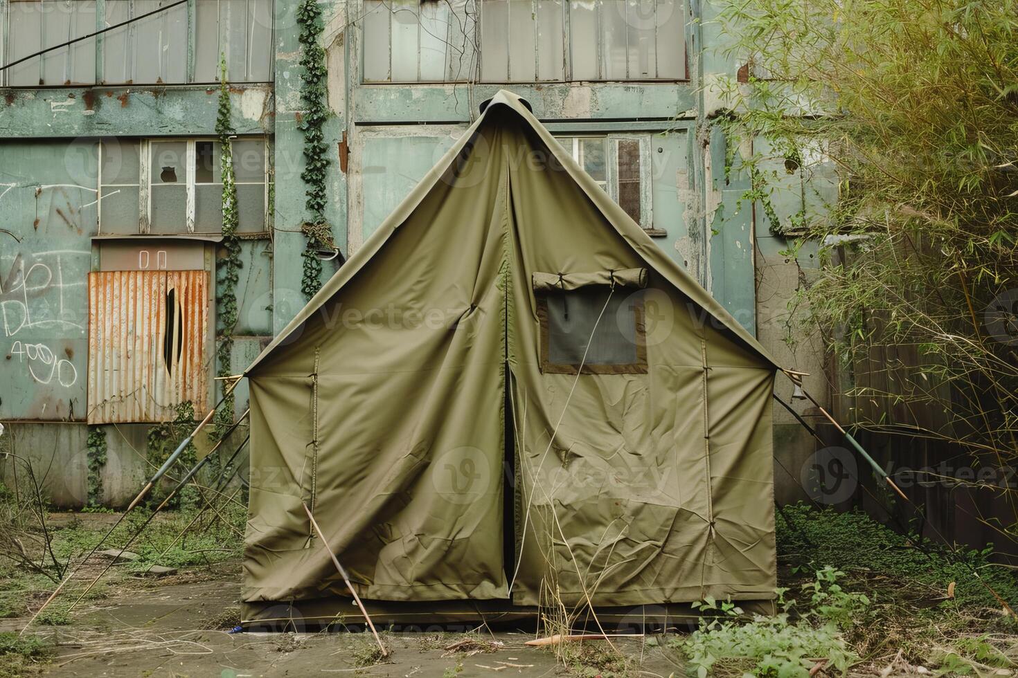 Khaki tent standing in front of abandoned building photo