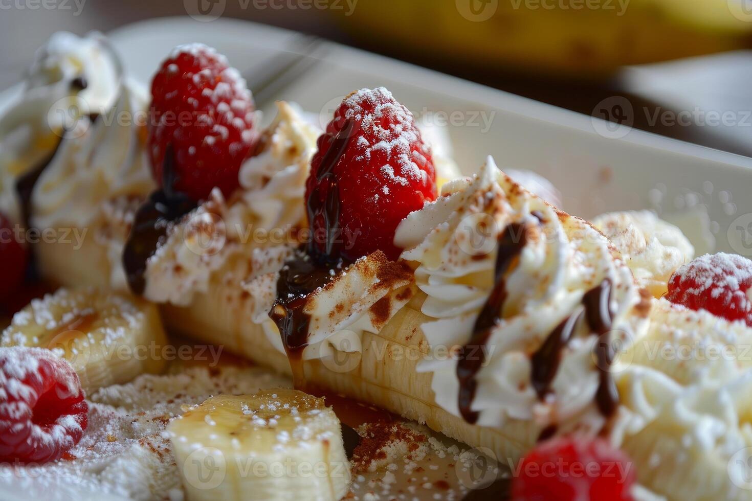 Banana split dessert indulging with raspberries chocolate sauce and whipped cream photo
