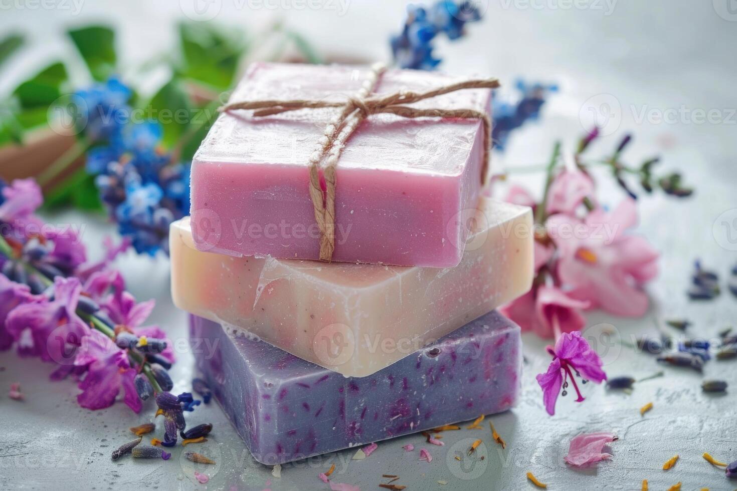 Stack of colorful handmade soap bars lying on gray surface with flowers photo