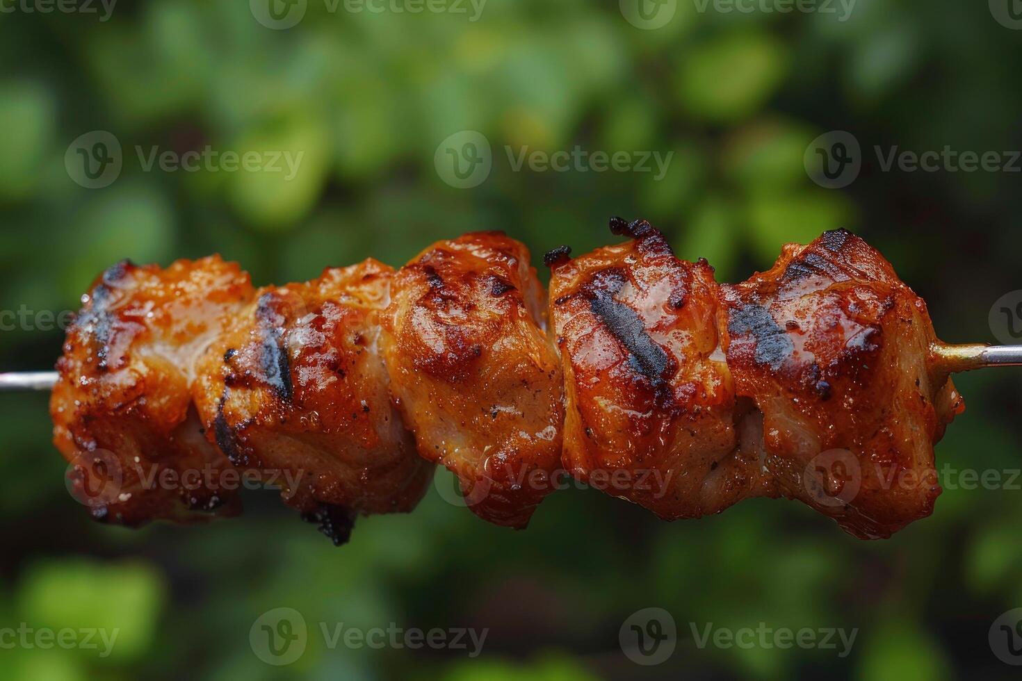 Barbecue skewer grilling on a green background photo