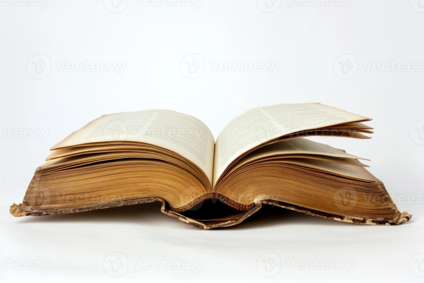 Open antique book lying on white background showing text and aged pages photo