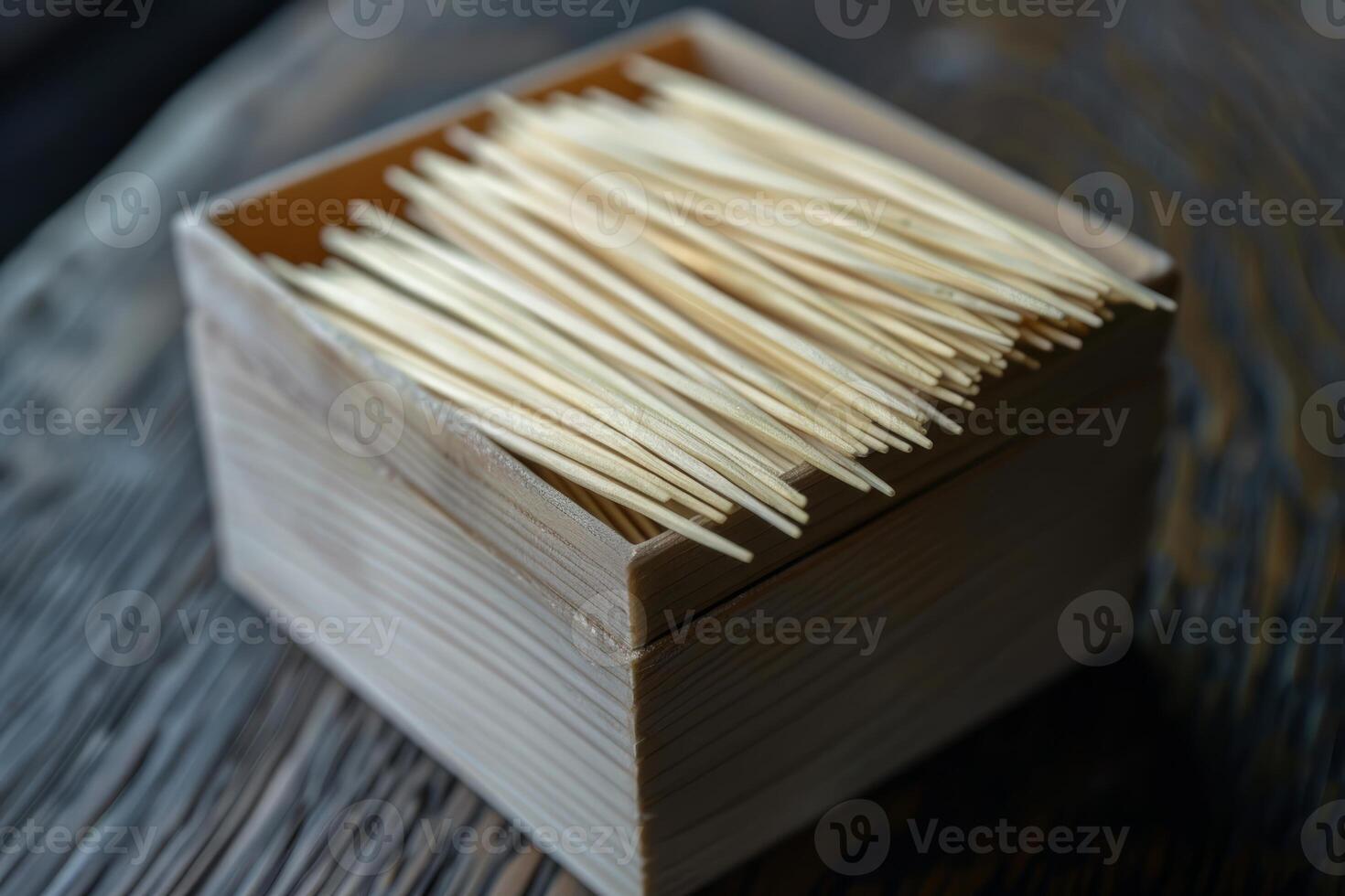Wooden toothpicks filling a small container on a rustic table photo