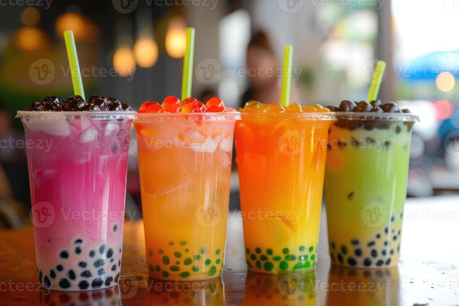 Four colorful bubble teas with boba pearls and popping boba resting on cafe counter photo