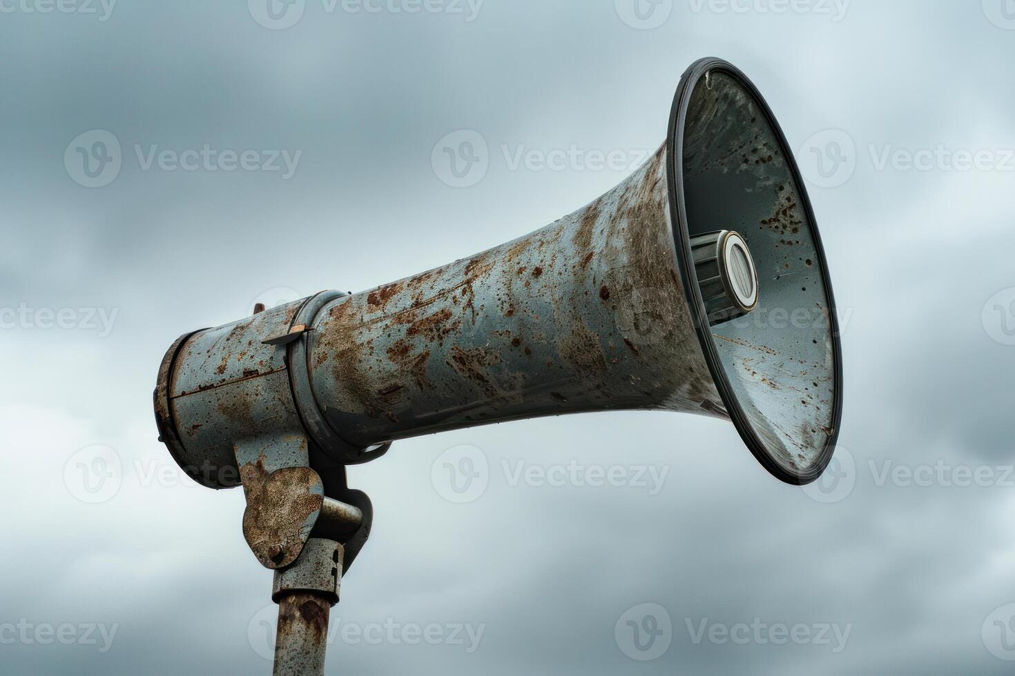 Old rusty loudspeaker is making an announcement under cloudy sky photo